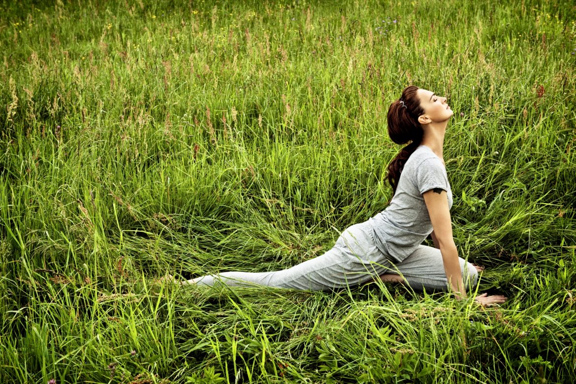 Agnieszka Maciąg ćwiczy jogę i medytuje na trawie.