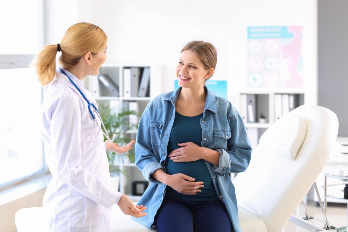 Badania prenatalne - co warto o nich wiedzieć? Kobieta w ciąży na wizycie lekarskiej u ginekologa.