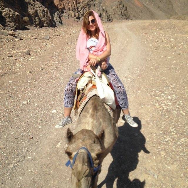 Beata Sadowska z niemowlakiem na wielbłądzie na pustyni.