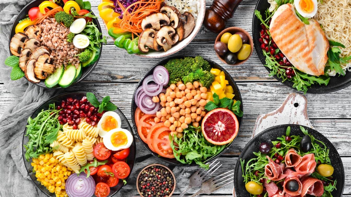 Buddha bowl z warzywami, owocami i nasionami na kilku półmiskach. Jak skomponować zdrową miskę Buddy?