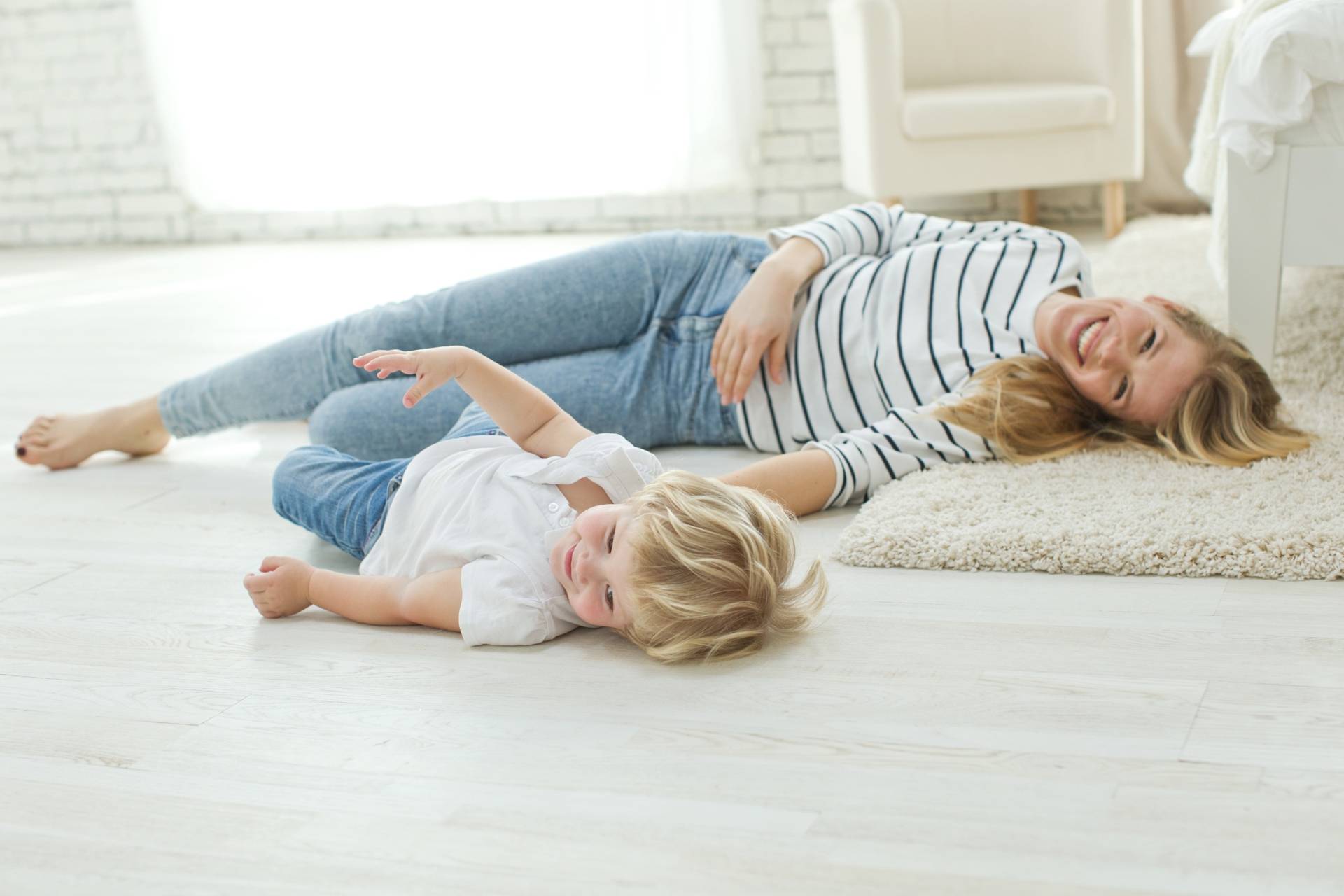 Bunt dwulatka - jak sobie z nim radzić? Mama bawi się na podłodze z synkiem.