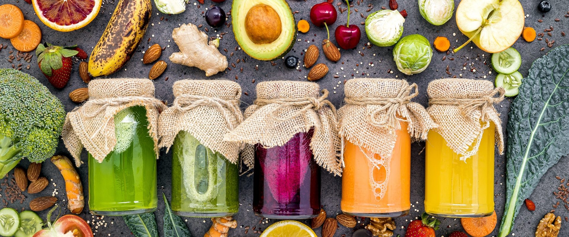 Przepisy na koktajle na odporność. Widok z góry na słoiki z kolorowymi, domowymi koktajlami i smoothies warzywno-owocowymi.