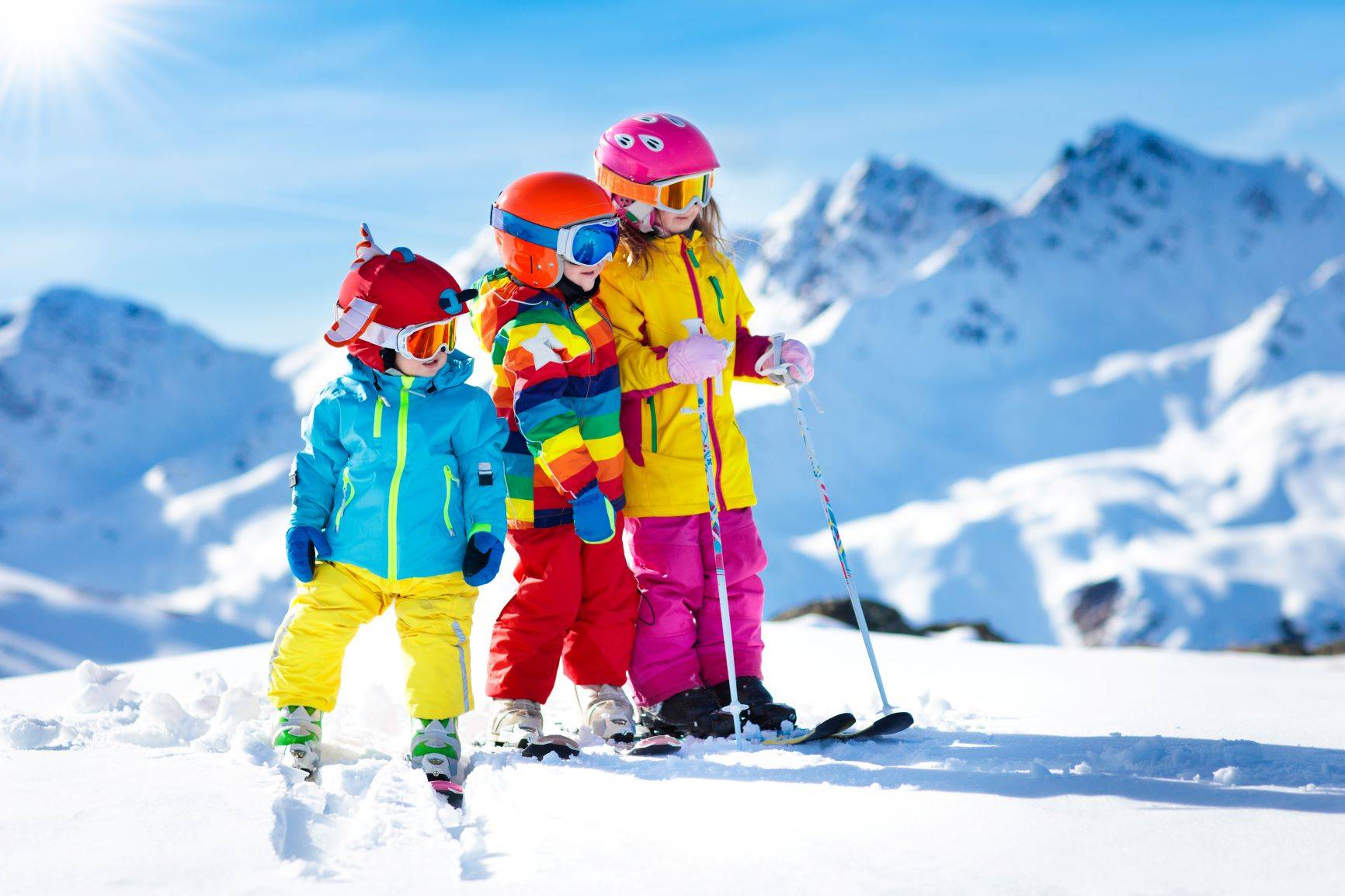 Czy warto jeździeć z instruktorem narciarstwa? Dzieci na nartach na stoku górskim.