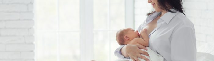Karmienie piersią - fakty i mity. Kobieta karmi piersią noworodka.