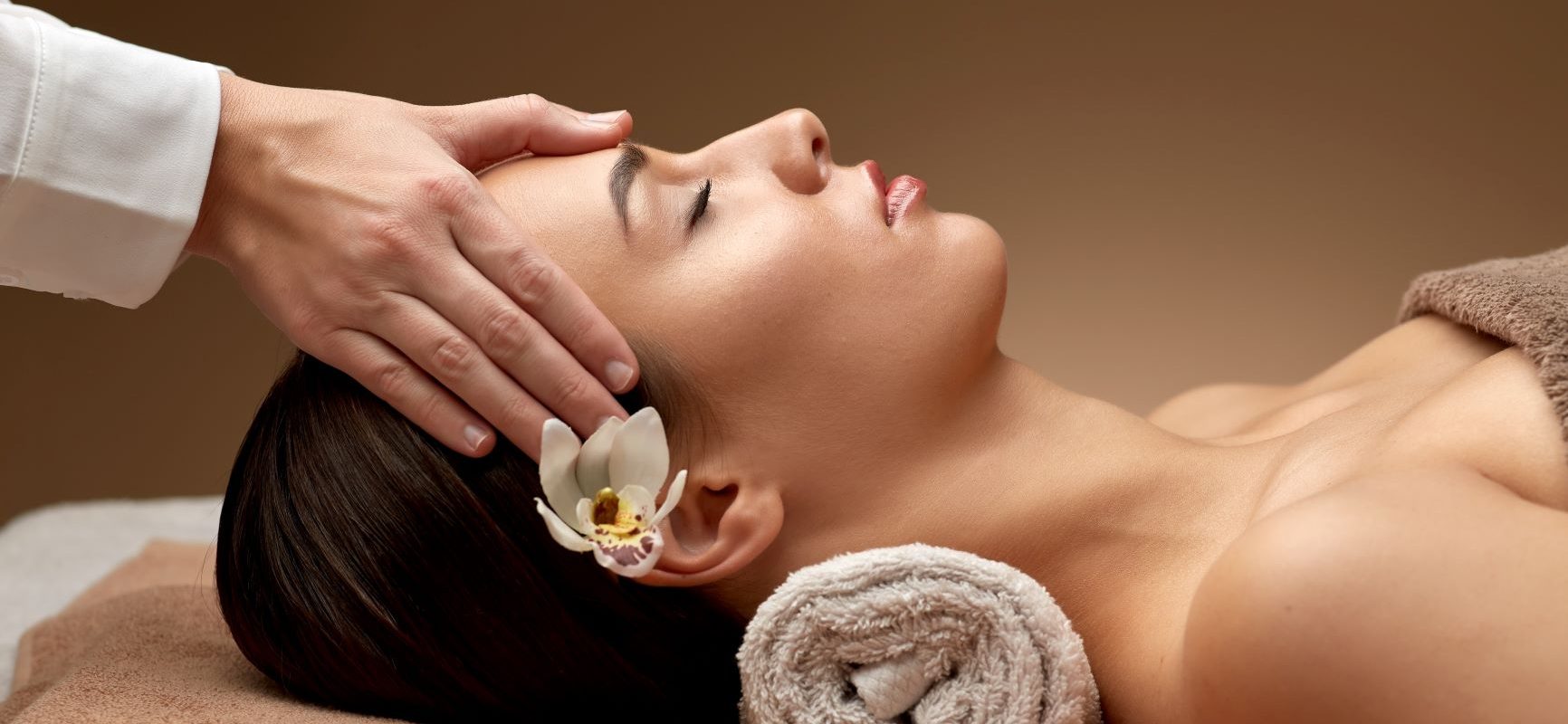 Japoński masaż twarzy - co warto o nim wiedzieć? Kobieta podczas zabiegu twarzy w gabinecie masażu.