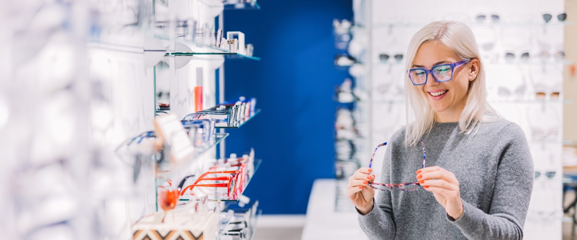 Choroby oczu - jak je rozpoznać? Dlaczego warto regularnie chodzić na wizytę do okulisty? Kobieta wybiera okulary u optyka.