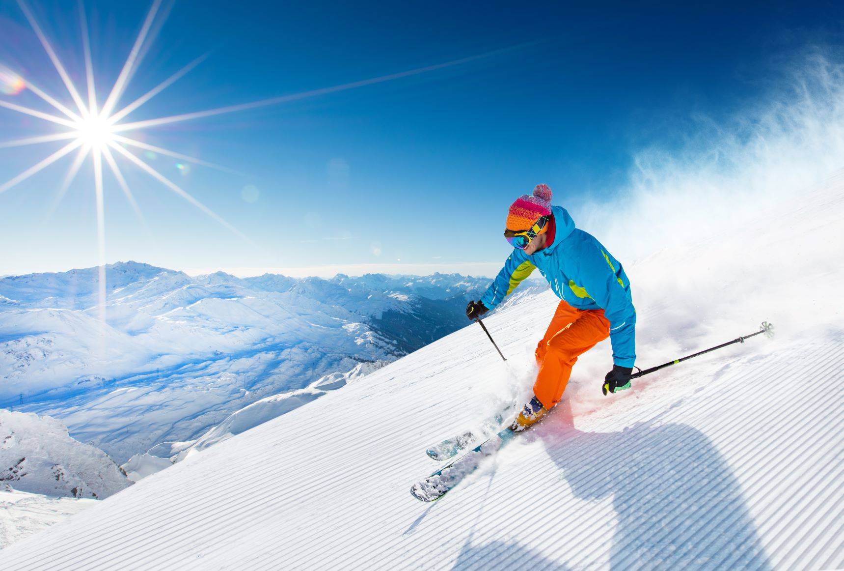 Jazda na nartach. Ćwiczenia przed nartami. Mężczyzna zjeżdża na nartach ze stoku.