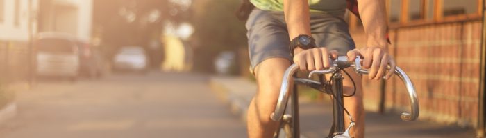 Czy jazda na rowerze może zmniejszać liczbę plemników i pogarszać jakość nasienia. Mężczyzna w czerwonej koszuli w kratę jeździ na rowerze.