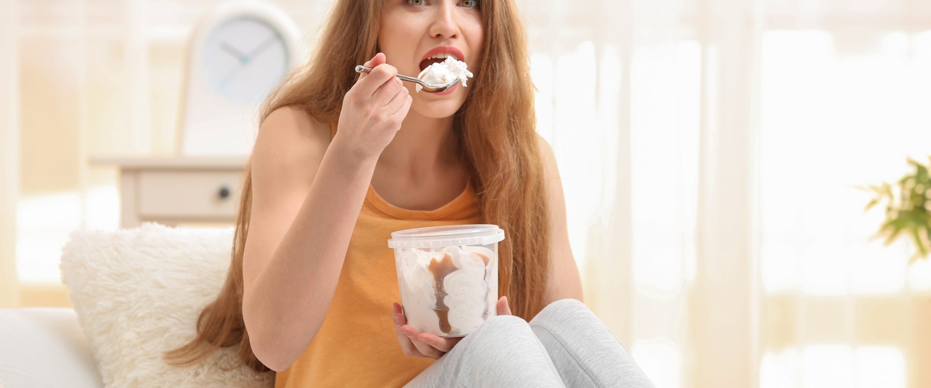 Kompulsywne jedzenie - jak sobie z nim radzić? Kobieta objada się lodami.