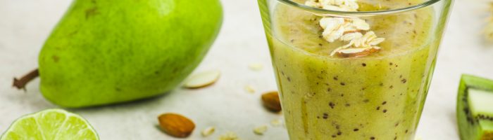 Sprawdź przepis na kompot gruszkowo-migdałowy na przeziębienie. Szklanka syropu gruszkowo-migdałowego, wokół leżą gruszki i migdały.