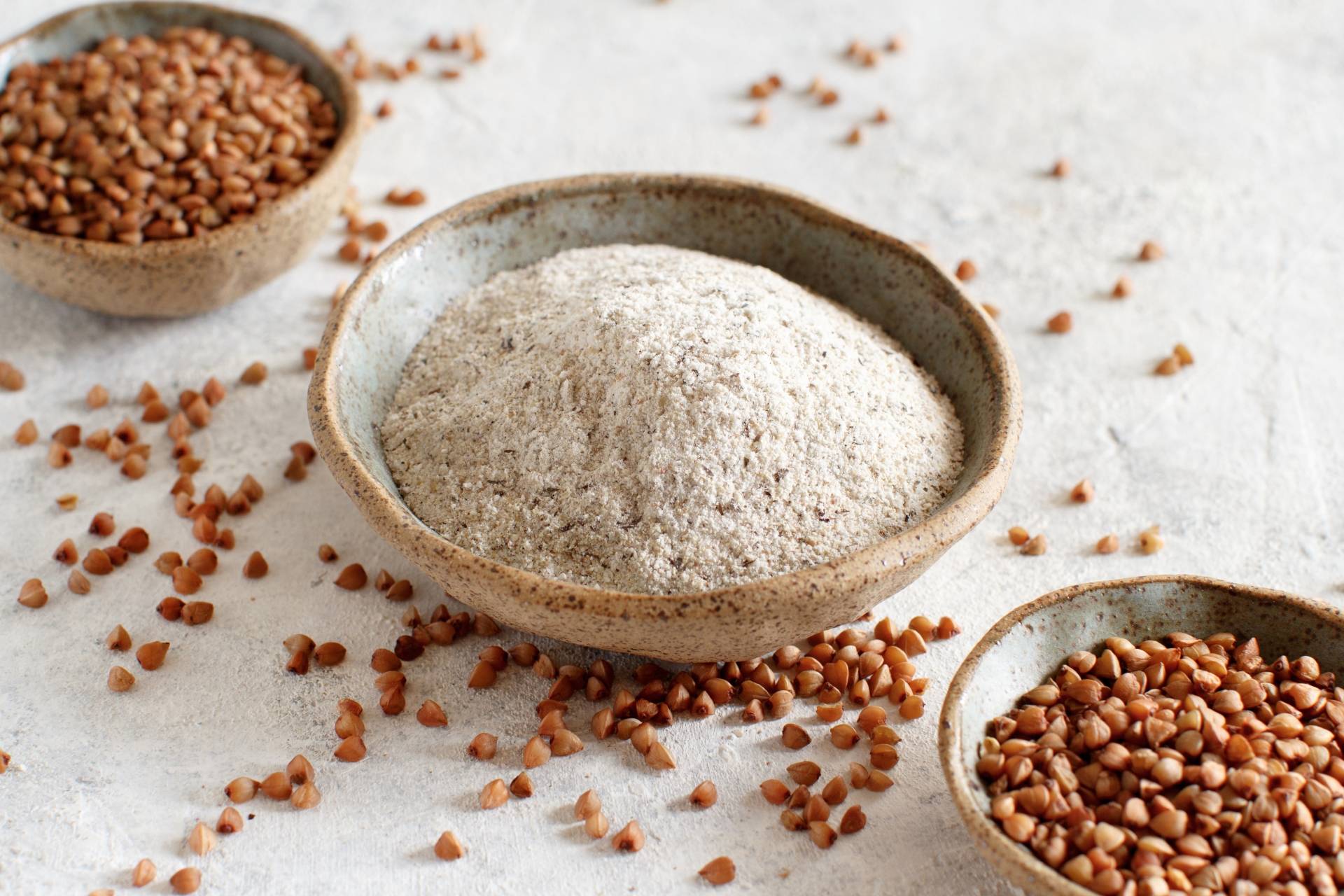 Mąki bezglutenowe. Mąka gryczana i kasza gryczana w miseczkach