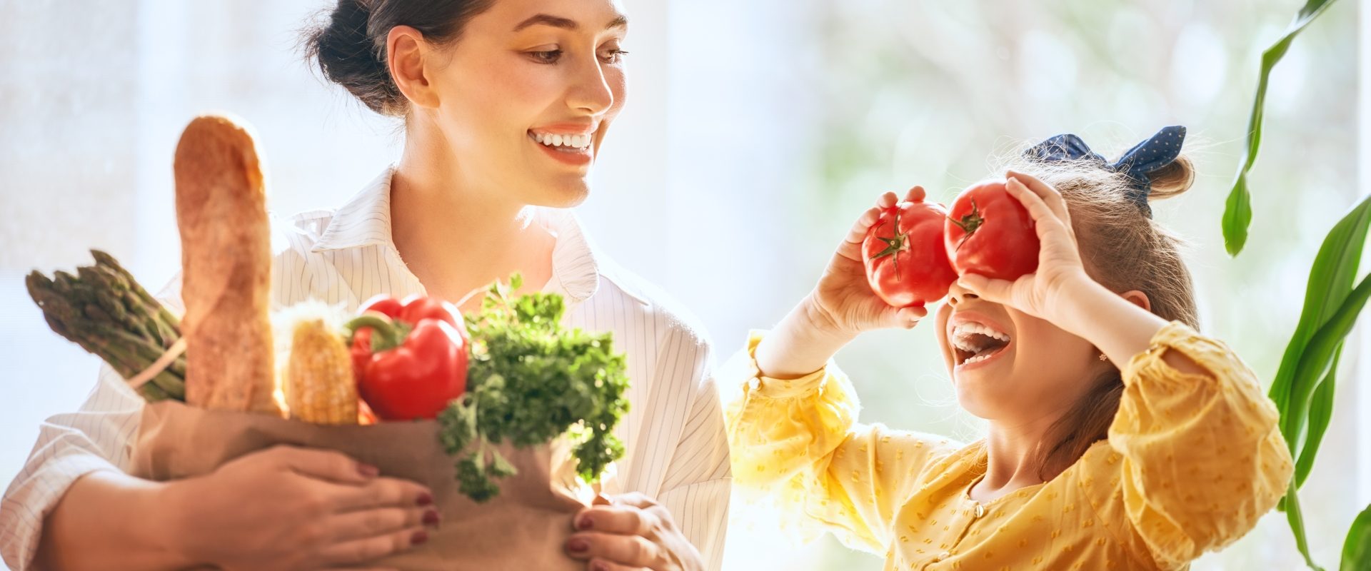 Witaminy na odporność - czy warto je suplementować? Mama i córka niosą zakupy w papierowej torbie.