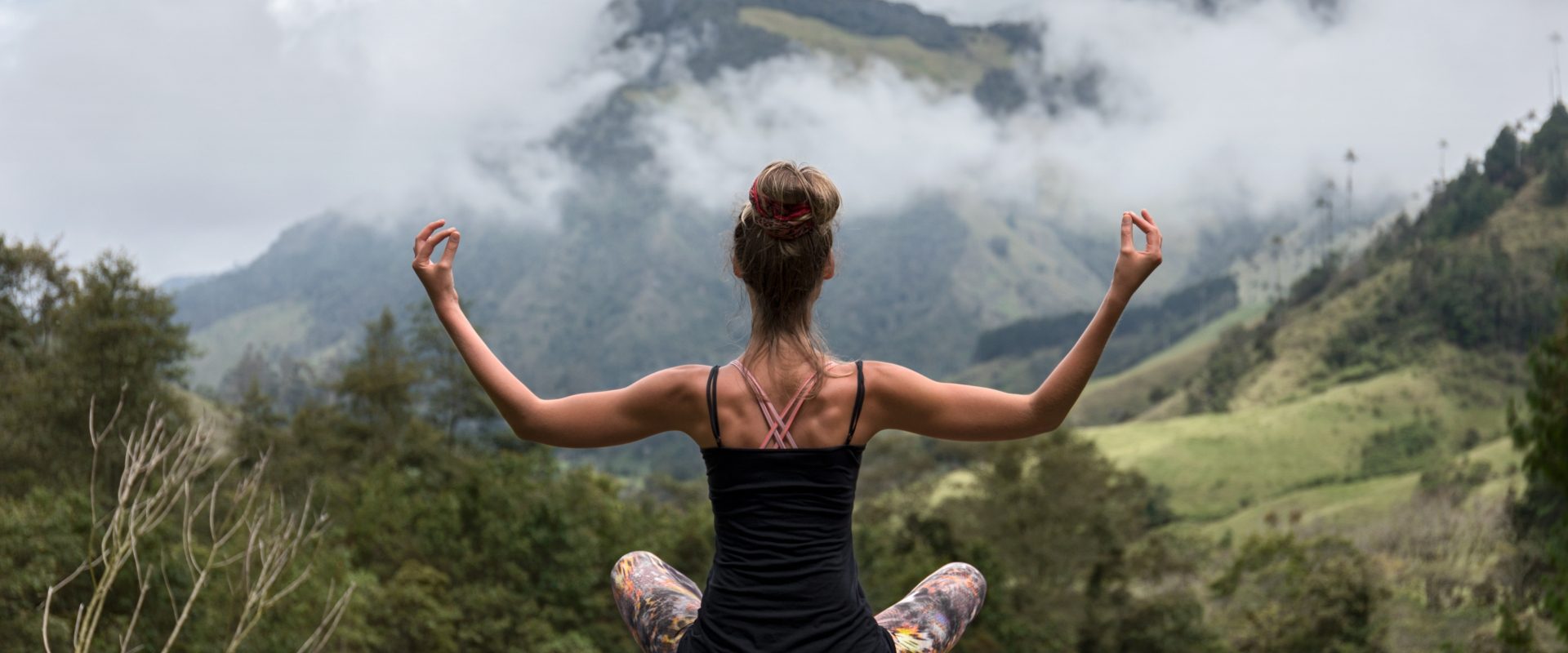 Jak ulepszyć praktykę jogi? Młoda wysportowana kobieta medytuje w górach.