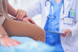 Masz mięśniaki macicy? Odstaw nabiał! Lekarz trzyma pacjentkę za rękę, pocieszając ją po postawieniu diagnozy.