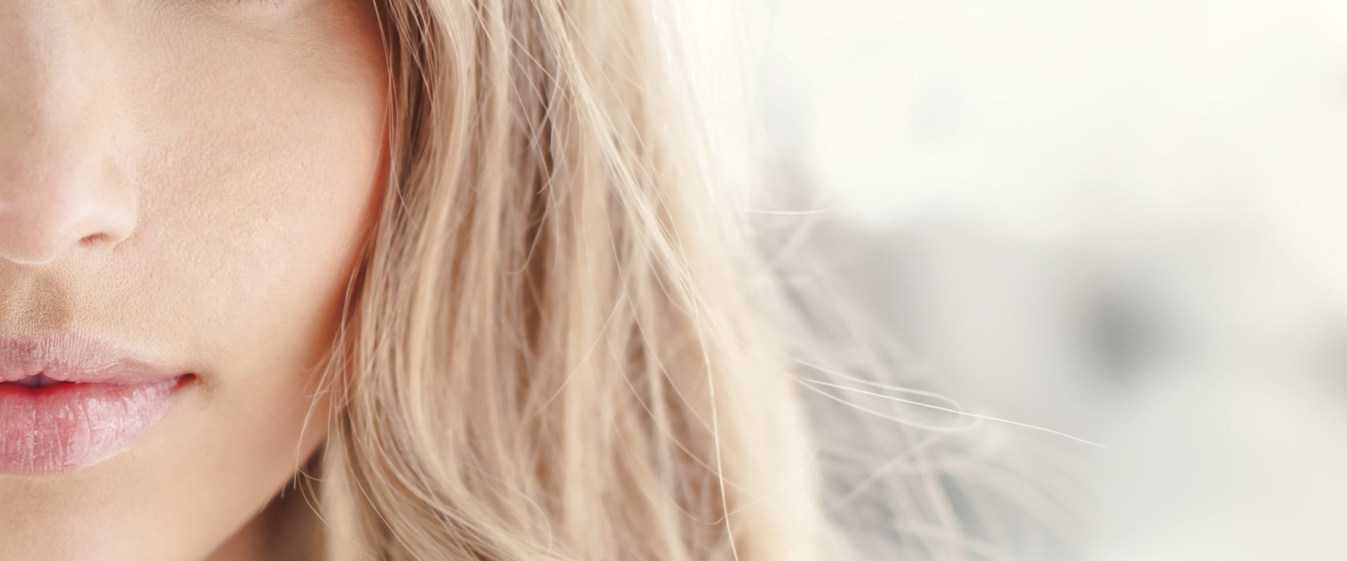 Niedoczynność tarczycy - większość osób nie wie, że ją ma. Jakie są objawy, przyczyny, leczenie i dieta? Zbliżenie na połowę kobiecej twarzy w delikatnym makijażu.