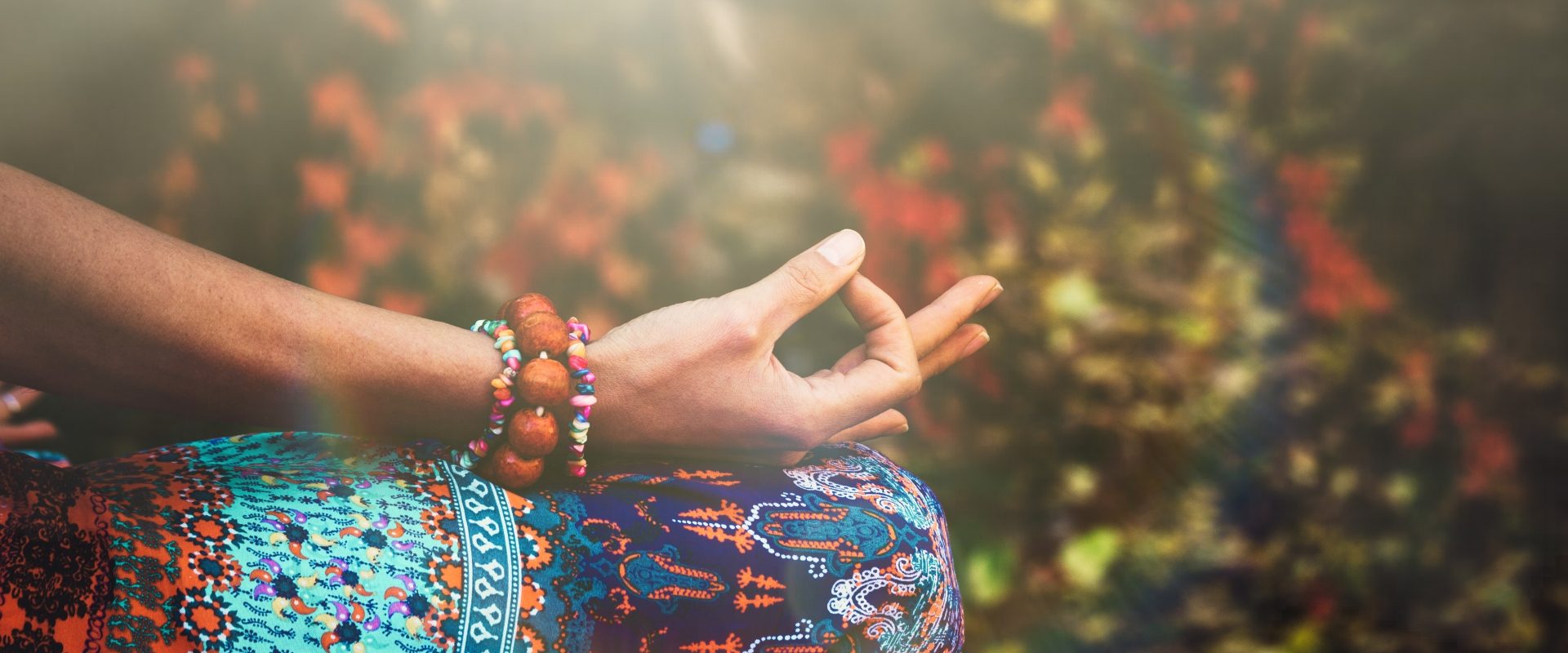 Mudry - gesty dłoni w ajurwedzie. Kobieta ćwiczy jogę lub medytuje układając dłonie w mudry.