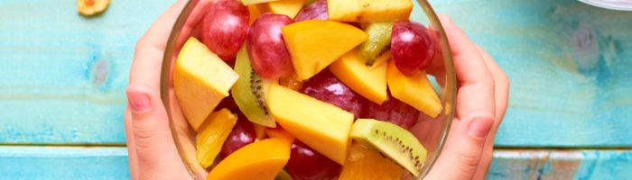 Nietolerancja fruktozy - objawy, przyczyny, leczenie, jadłospis. Pokrojone owoce w miseczce na niebieskim blacie.