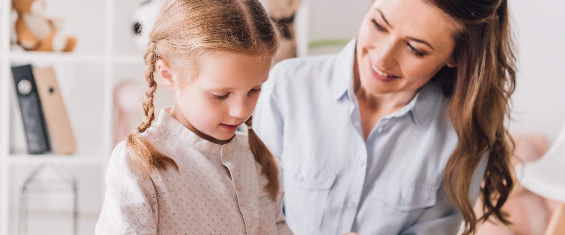 Wysoko wrażliwe dziecko - jak się nim dobrze zaopiekować? Młoda mama pomaga córeczce ułożyć klocki.