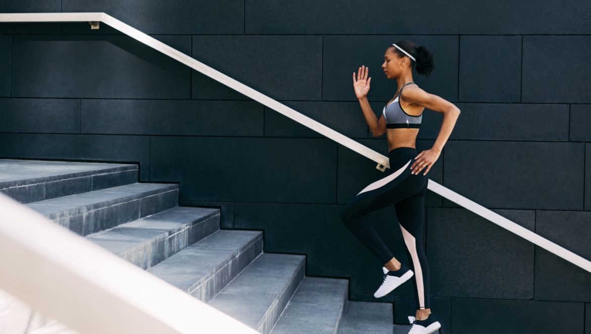 Pamięć mięśniowa - czym jest? Jak działa pamięć ciała i pamięć ruchowa? Wysportowana kobieta w sportowym stroju wbiega po schodach.