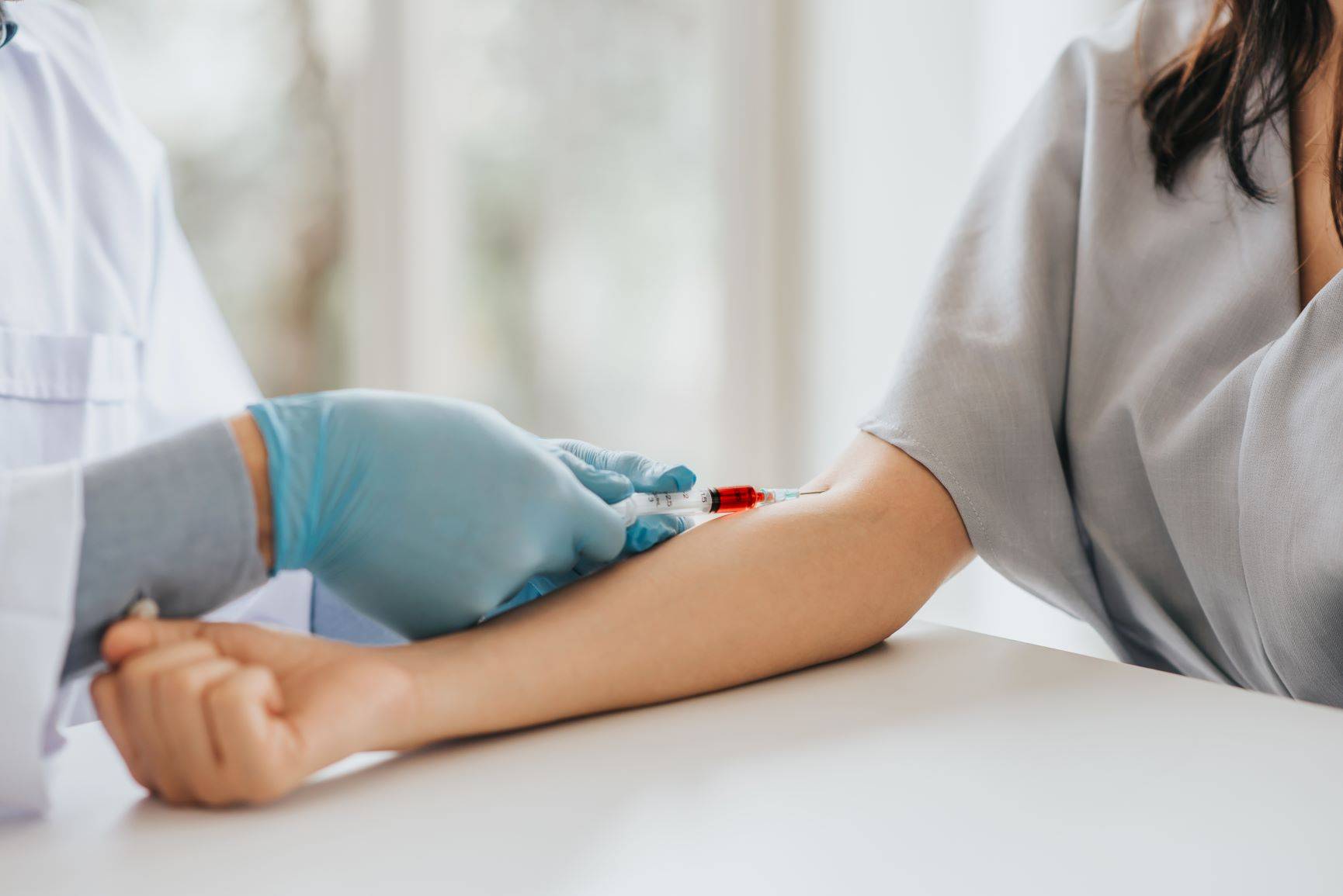 Pobranie krwi - jak się przygotować do zabiegu? Co zrobić, aby krew była rzadsza, a żyły lepiej widoczne przez pobraniem? Pielęgniarka pobiera krew pacjentce.