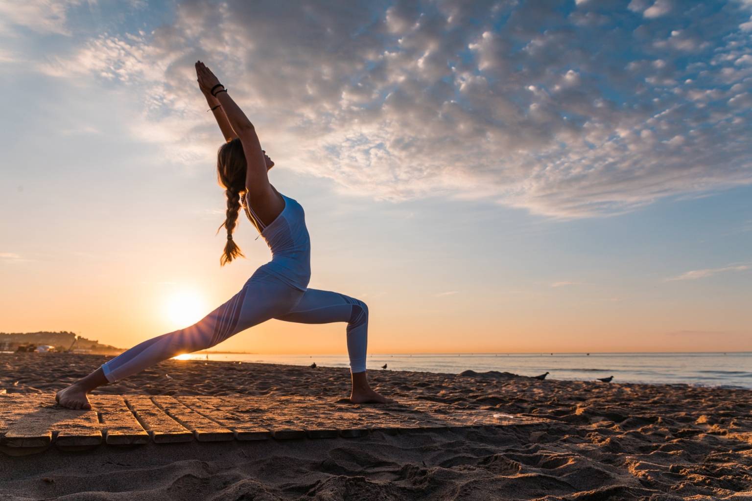 Joga klasyczna Ashtanga joga- na czym polega ośmiostopniowa ścieżka jogi. Kobieta ćwiczy jogę o zachodzie słońca na plaży.