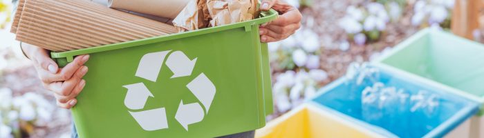 Czym zastąpić plastik - alternatywy dla plastiku? Kobieta trzyma pojemnik do recyklingu i segreguje śmieci.