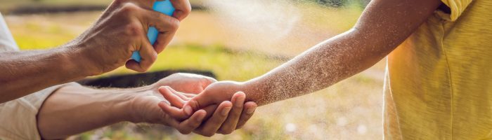 Domowe i naturalne sposoby na komary, kleszcze i inne owady. Jak zrobić domowy spray na komary? Ojciec pryska środek na komary na rękę dziecka.