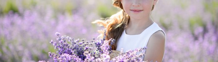 Rośliny odstraszające owady: komary, muchy, osy, pszczoły, mole. Dziewczynka trzyma bukiet zebranej lawendy na polu lawendowym.