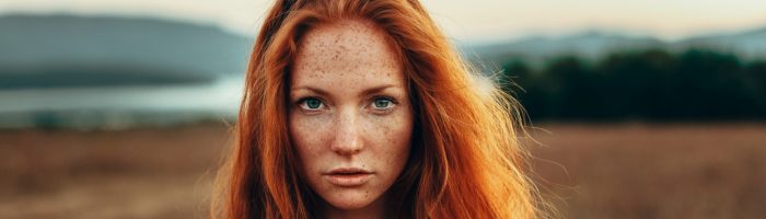 Yin i yang miesiączki w medycynie chińskiej. Jak zadbać o siebie podczas menstruacji? Portret pięknej rudowłosej dziewczyny, stojącej na mokradłach nad brzegiem oceanu.