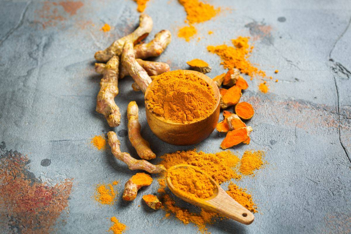 Przepis na złote mleko z kurkumą. Sproszkowana kurkuma i korzeń kurkumy.