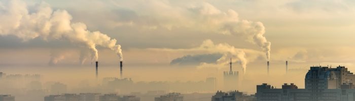 Skutki zanieczyszczenia powietrza - jak smog rujnuje zdrowie. Smog nad miastem, dym z kominów fabrycznych.