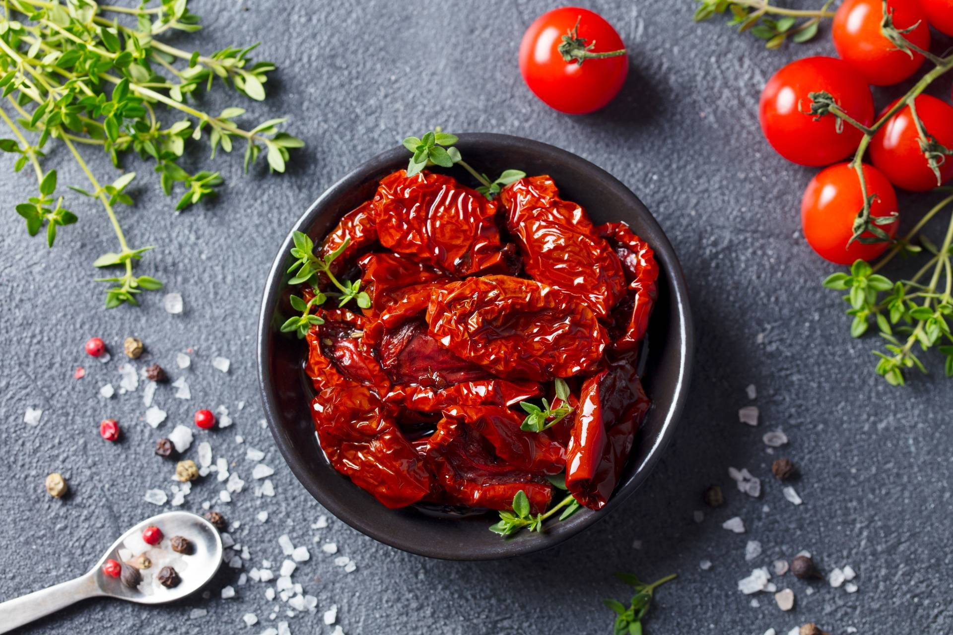 Suszone pomidory w czarnym półmisku. Sprawdź przepisy z pomidorami Agnieszki Żelazko.