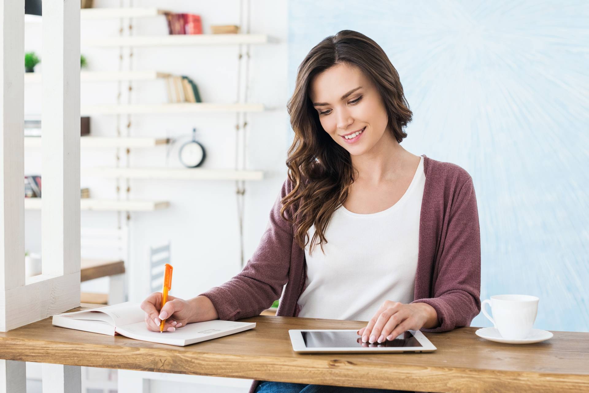 Trening mózgu - jak ćwiczyć pamięć? Kobieta siedzi przy biurku i robi notatki.