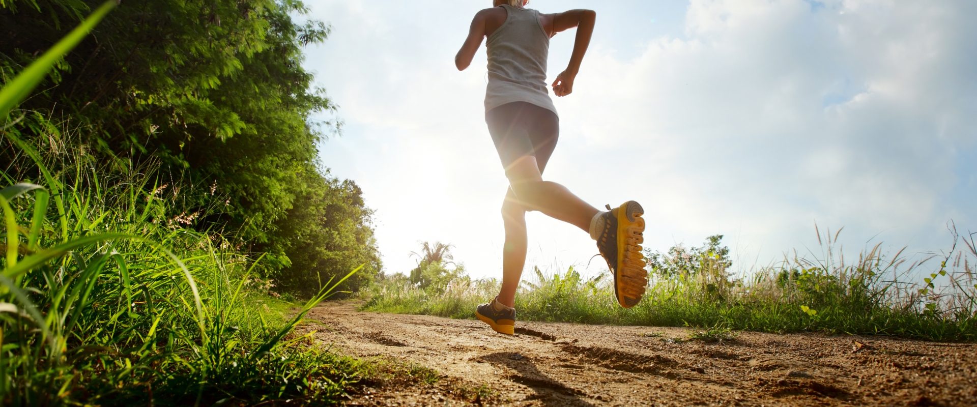 Trening na świeżym powietrzu - jak go wykonać? Fartlek i trening siłowy. Młoda wysportowana kobieta uprawia jogging na łonie natury.