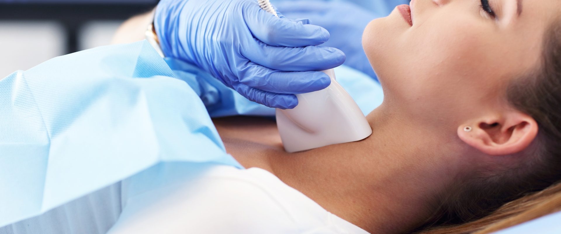 Kobieta u lekarza podczas badania USG tarczycy.