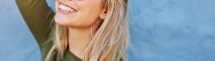 Sirtuiny - eliksir młodości, białka odpowiedzialne za długowieczność i szczupłą sylwetkę. Czym jest dieta sirt (sirtfood)? Uśmiechnięta kobieta w okularach przeciwsłonecznych.