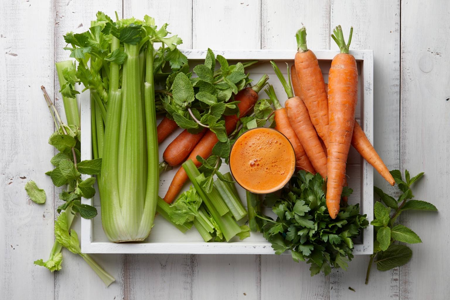 Jak myć owoce i warzywa, aby usunąć z nich pasożyty i chemiczne utrwalacze? Seler naciowy i marchewka w skrzynce na warzywa.