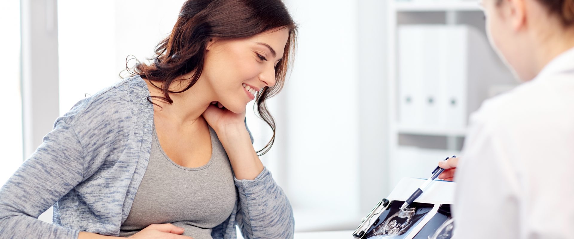 Badanie KTG w ciąży - dlaczego warto je wykonać? Kobieta w ciąży na wizycie u ginekologa.