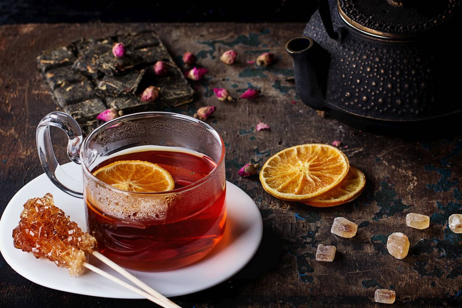 Czerwona herbata rooibos zaparzona w filiżance z plasterkiem pomarańczy.
