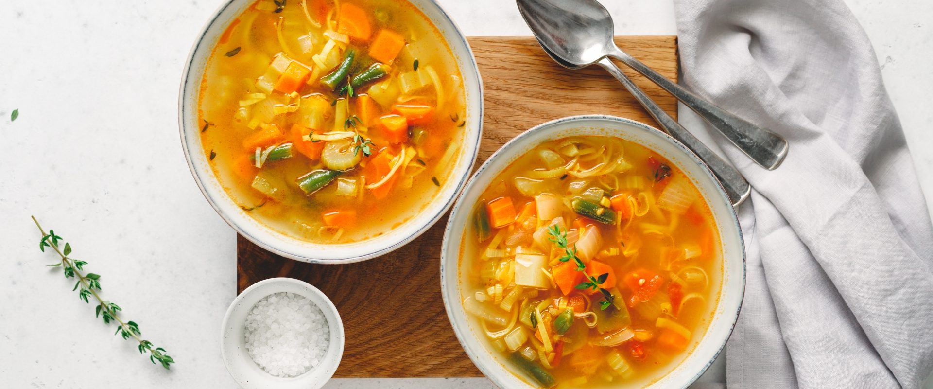 Zupy mocy - jak ugotować wzmacniającą zupę rozgrzewającą? Rosół z kury w białych miseczkach.